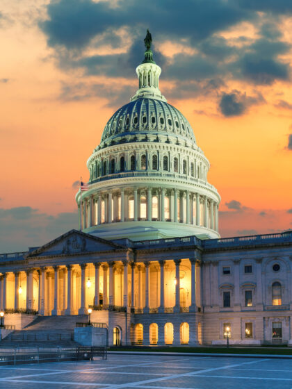 US Capitol Building at sunset with American flags is the home of the United States Congress in Washington D.C, USA.